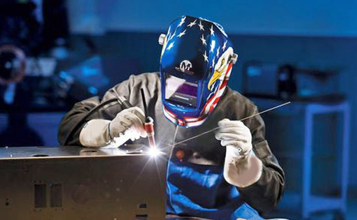 a man wearing a mask and gloves welding