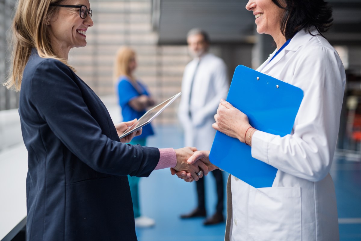 a woman shaking hands with a doctor