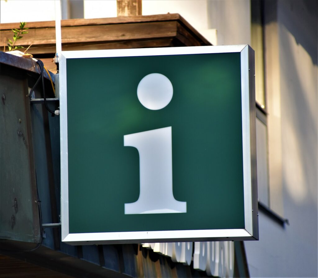 a green sign with a white letter on it