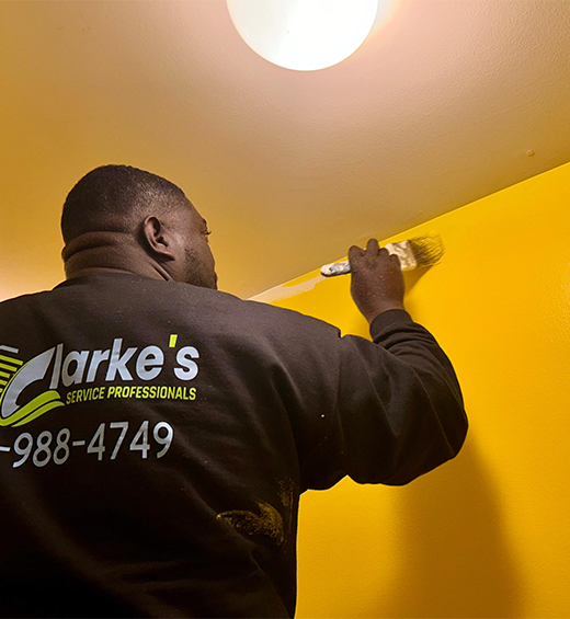 a man painting a yellow wall