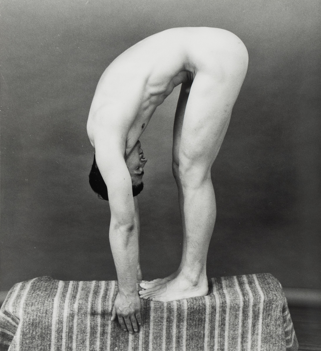 a man bending over on a piece of cloth