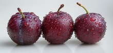 a row of plums with water droplets on them