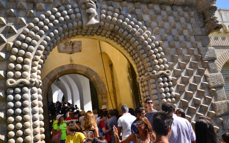 a group of people walking through a stone archway