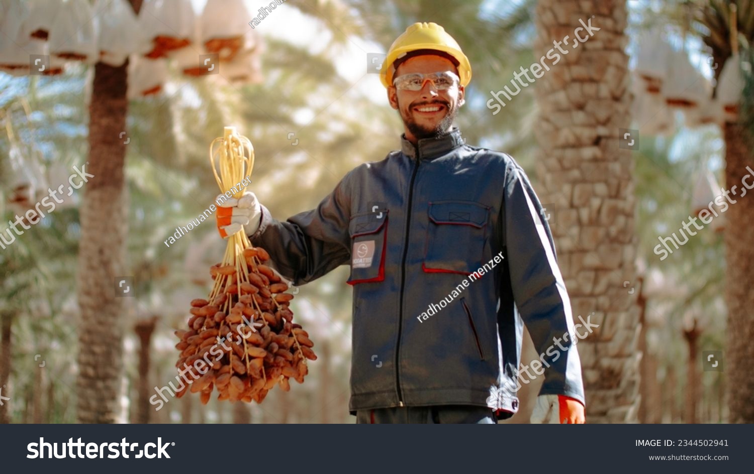 a man wearing a hard hat and holding bananas