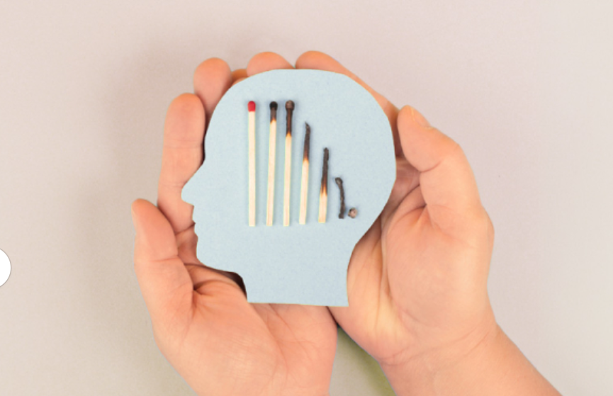 hands holding a paper cut out of a head with matches in the shape of a head