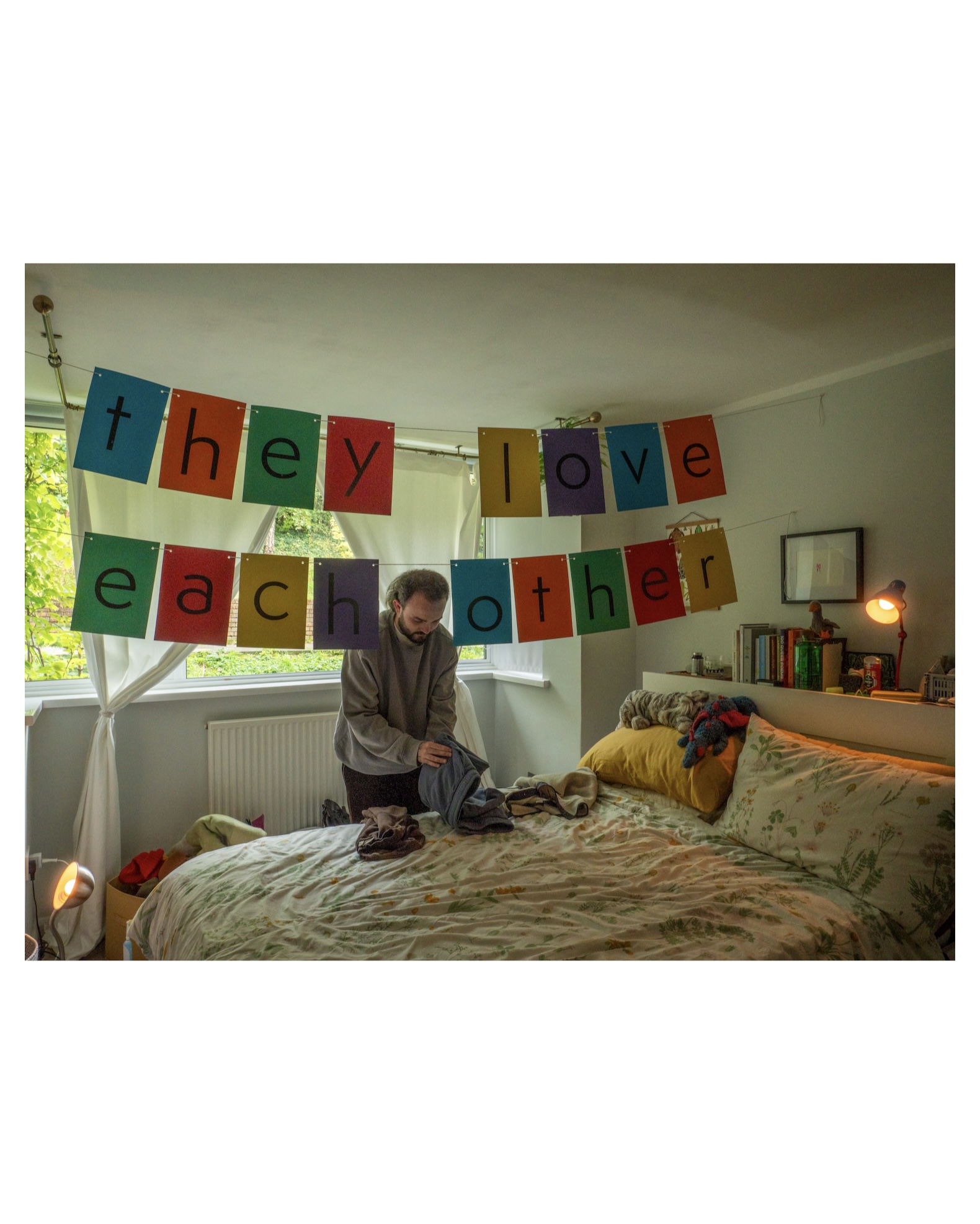 a man sitting on a bed with a sign above him