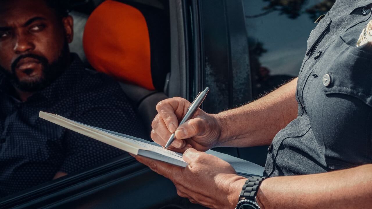 a person holding a pen and writing on a book