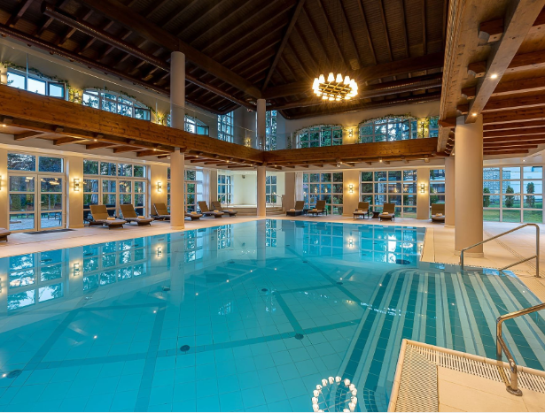 a large indoor swimming pool with chairs and a large ceiling