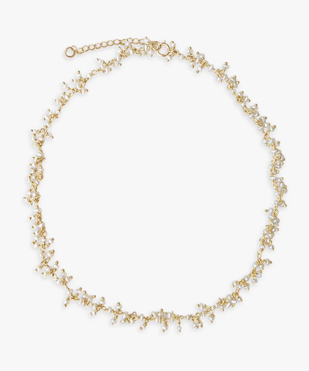 a gold necklace with white and gold beads