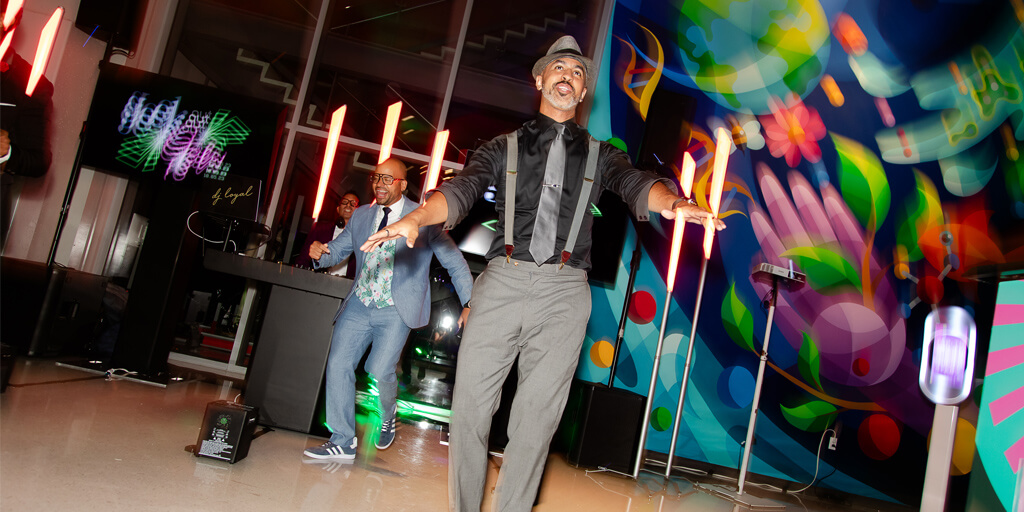 a man in a hat and suspenders dancing with other men