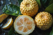 a group of yellow fruit with leaves