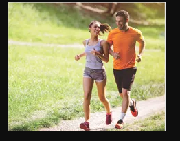 a man and woman running on a path