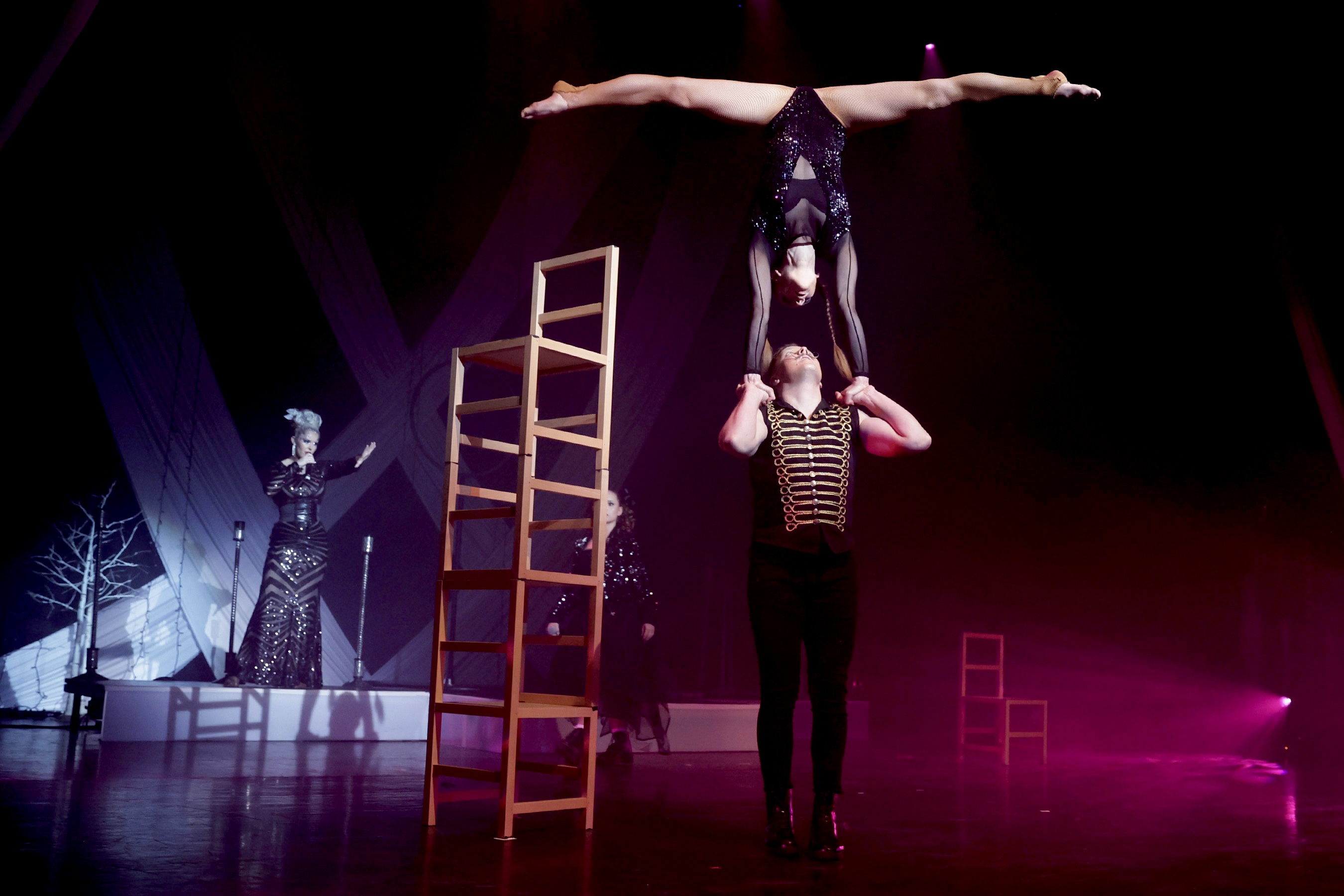 a man holding a woman upside down on a stage