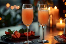 two glasses of pink liquid on a table