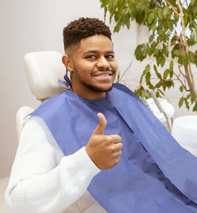 a man sitting in a chair giving a thumbs up