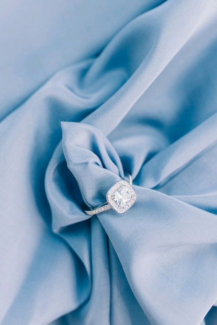 a diamond ring on a blue fabric