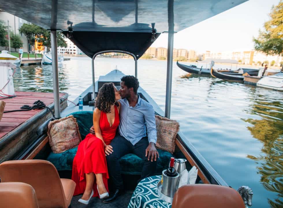 a man and woman kissing on a boat
