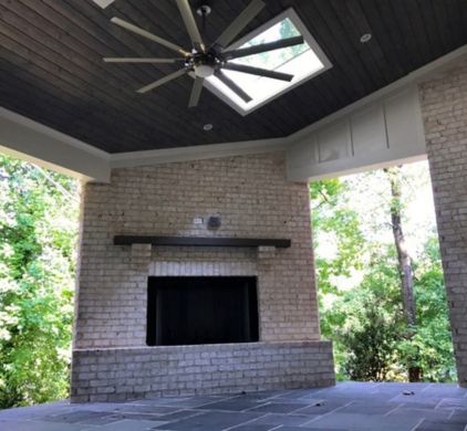 a brick fireplace with a ceiling fan