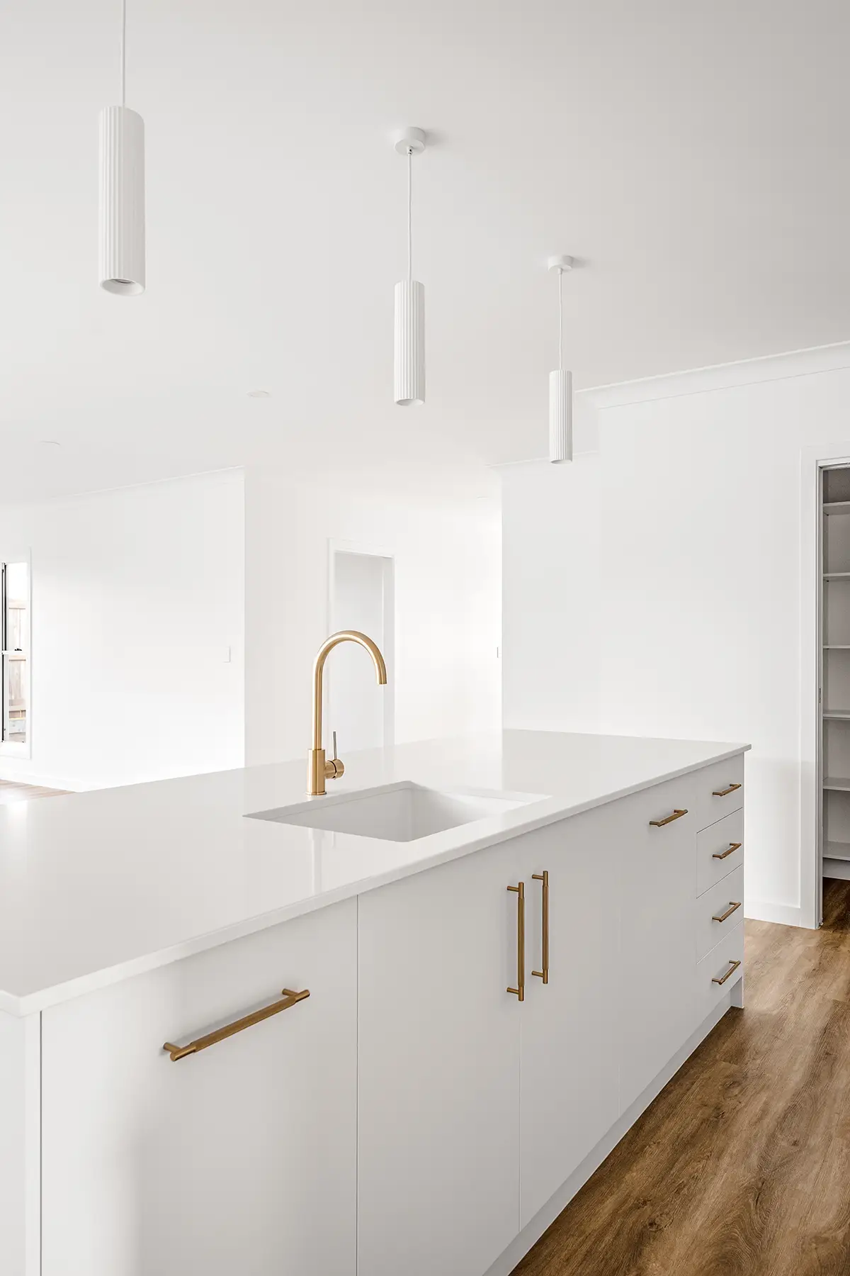 a white kitchen with a sink and cabinets