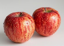 two apples on a white surface