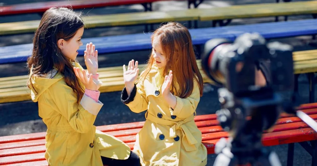 two girls in yellow coats clapping and giving high five