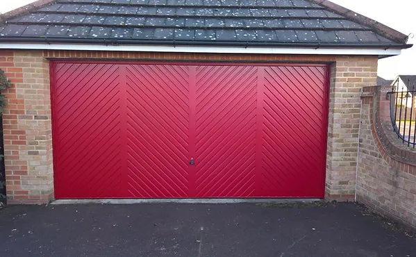 a red garage door with brick wall