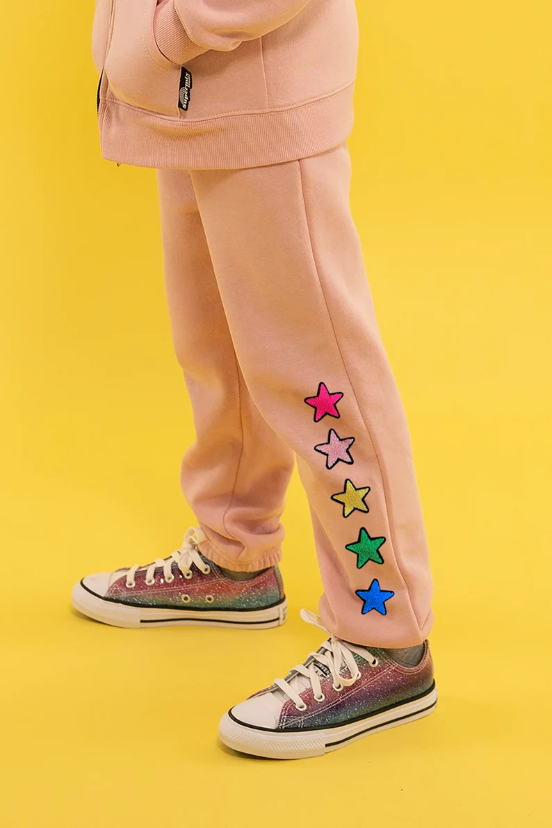 a person wearing pink pants with colorful stars on them