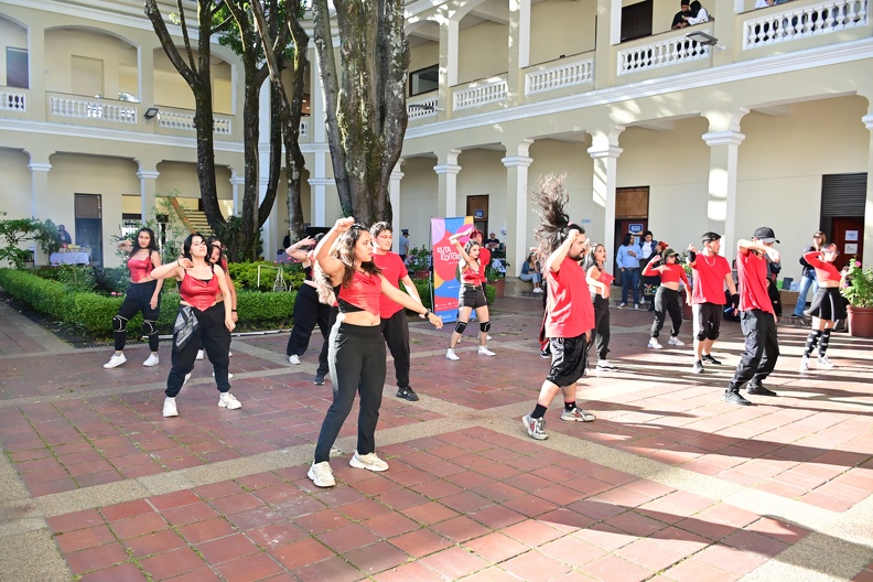 a group of people dancing in a courtyard