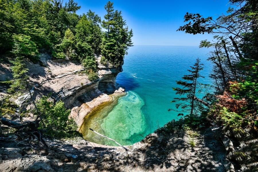 a cliff with trees and water