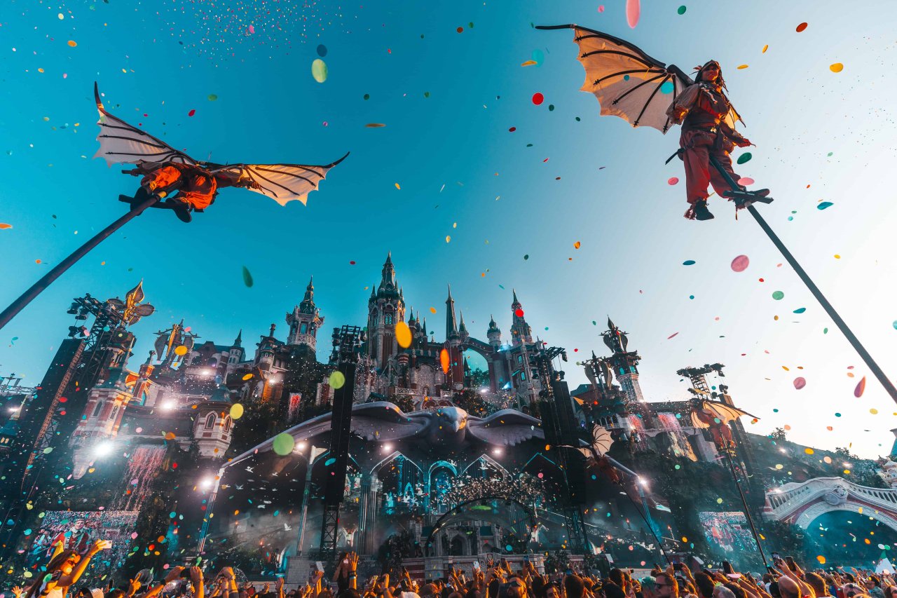 a group of people in clothing flying in the air with confetti