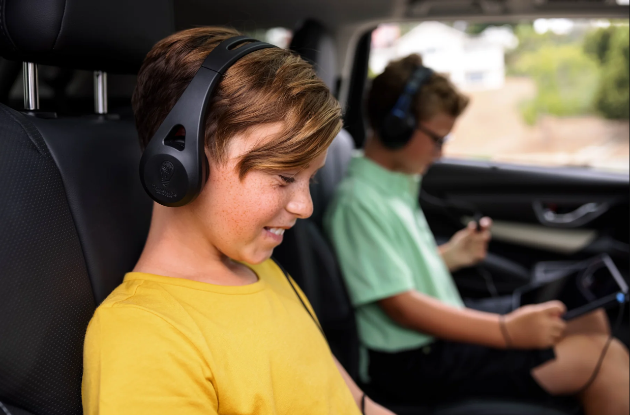 a boy wearing headphones in a car