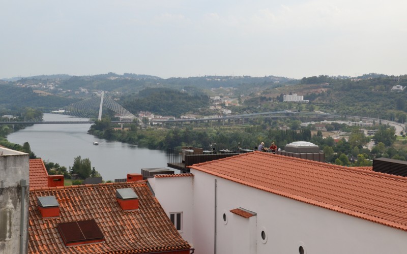 a group of buildings with red roofs and a river