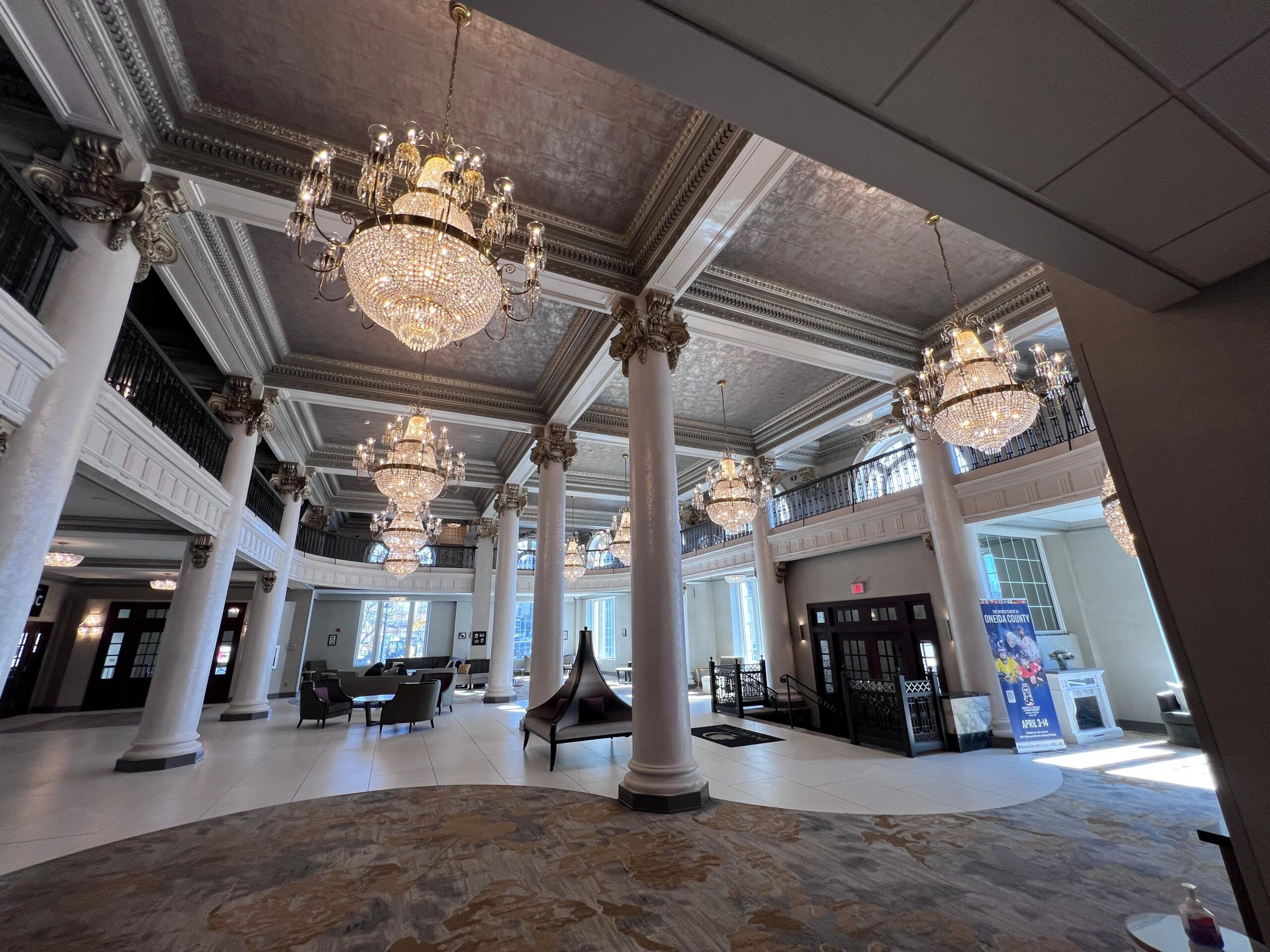 a large room with columns and chandeliers