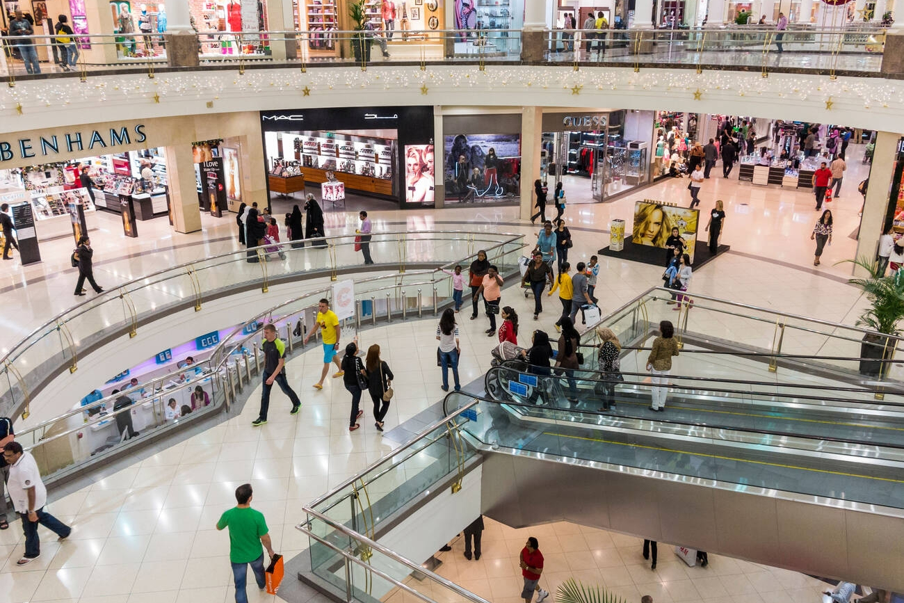 a large shopping mall with escalators and people