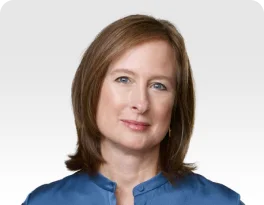 a woman with brown hair wearing a blue shirt