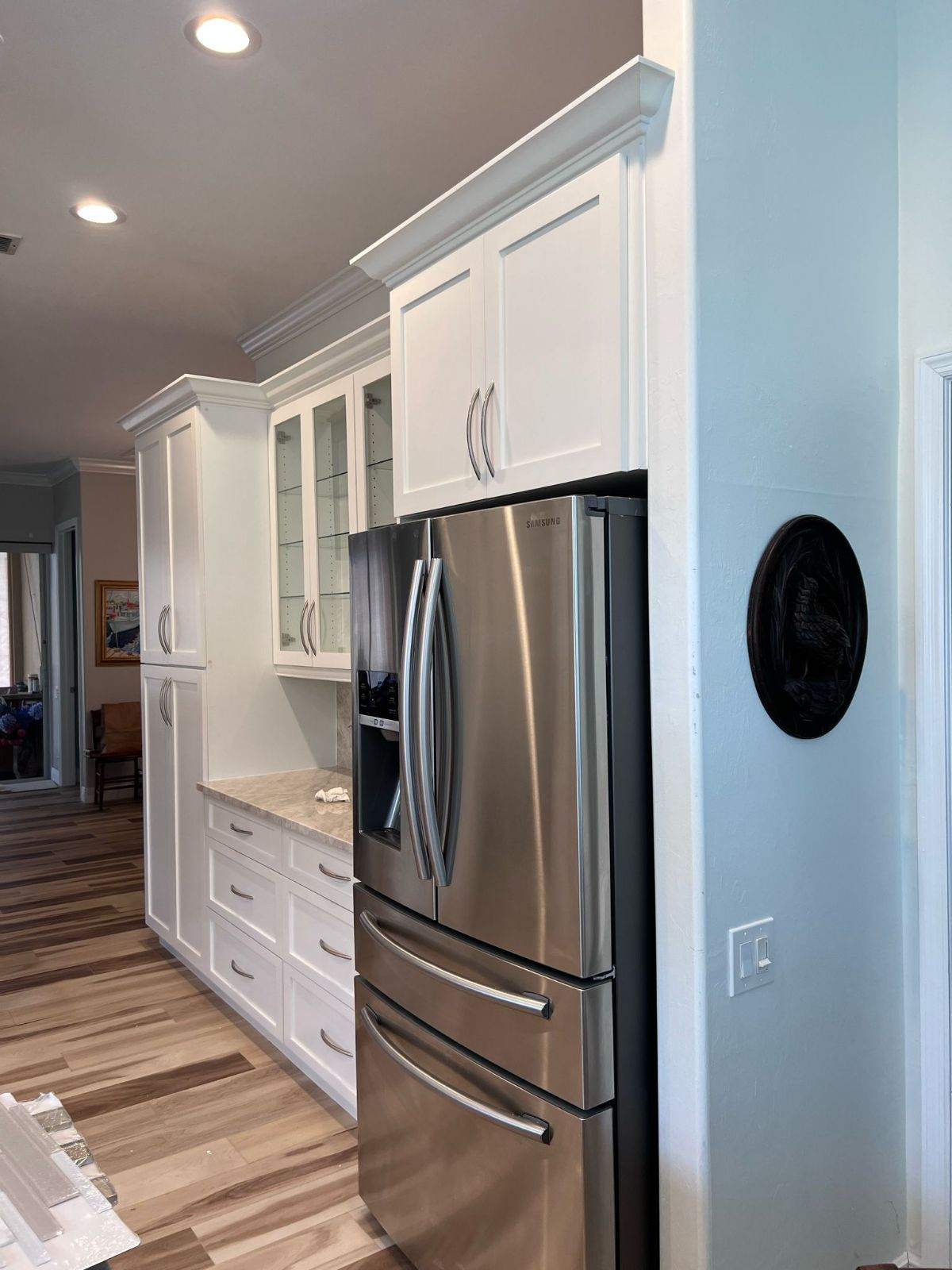a kitchen with white cabinets and stainless steel refrigerator