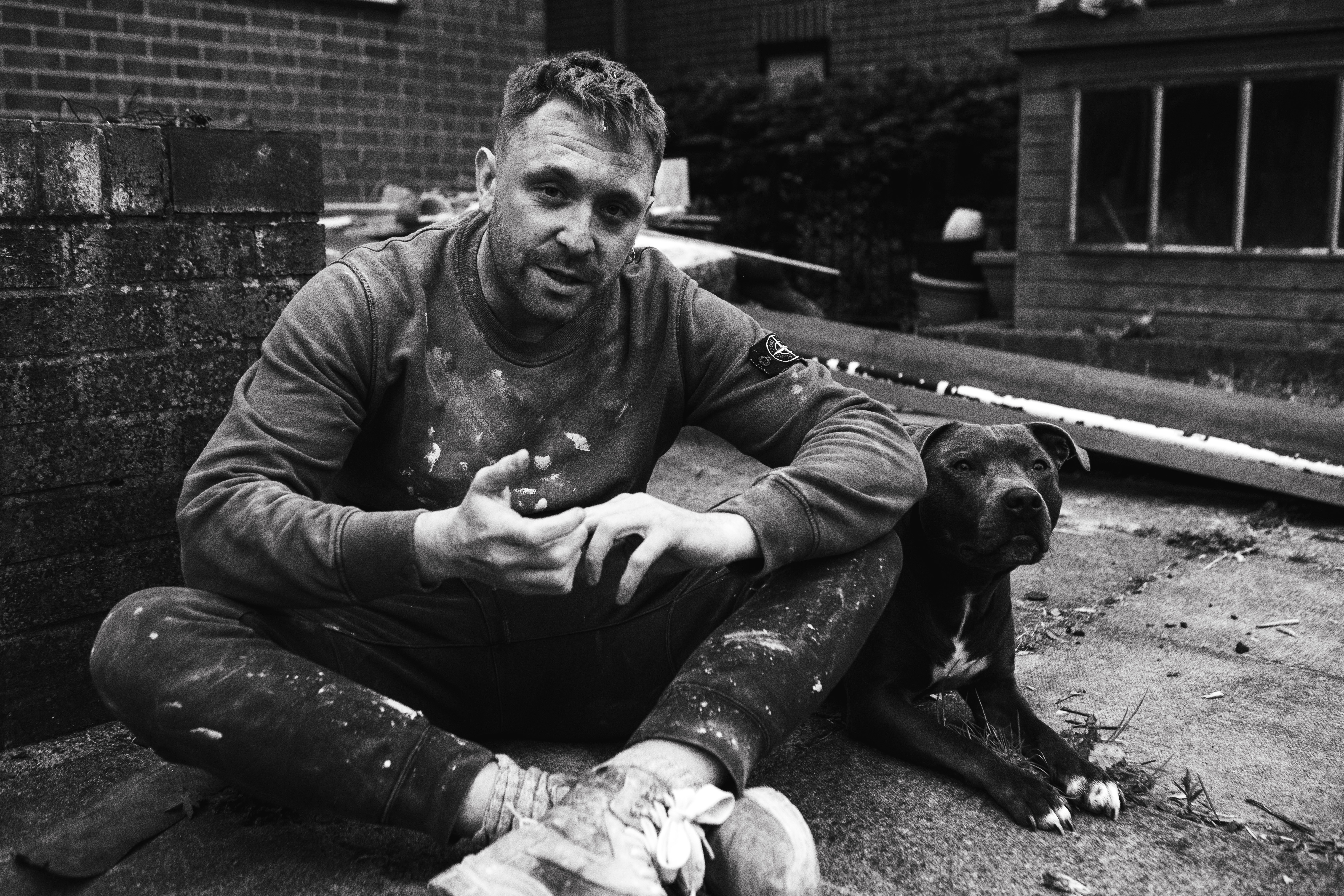 a man sitting on the ground with a dog