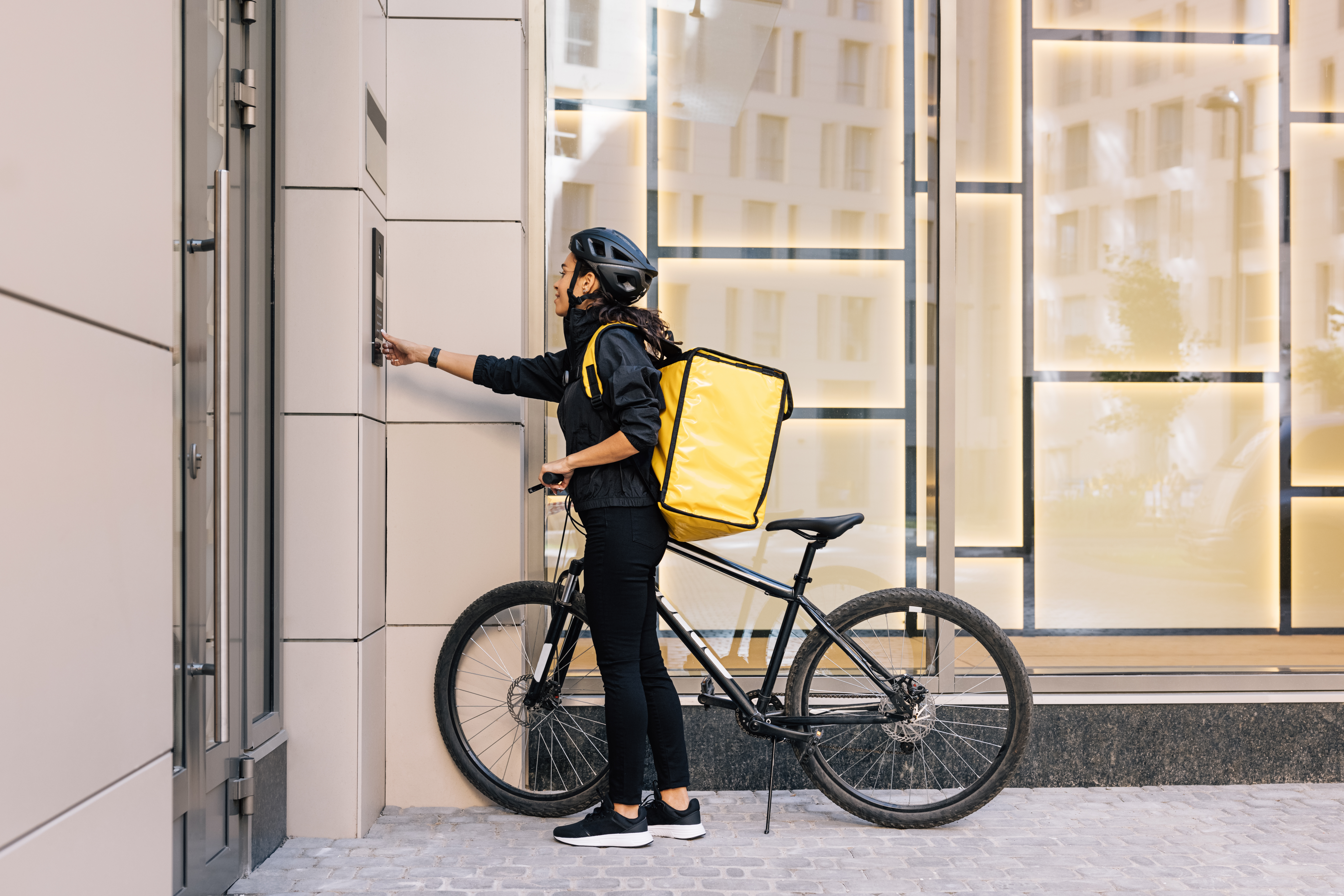 a woman with a bike and a yellow bag pushing a machine