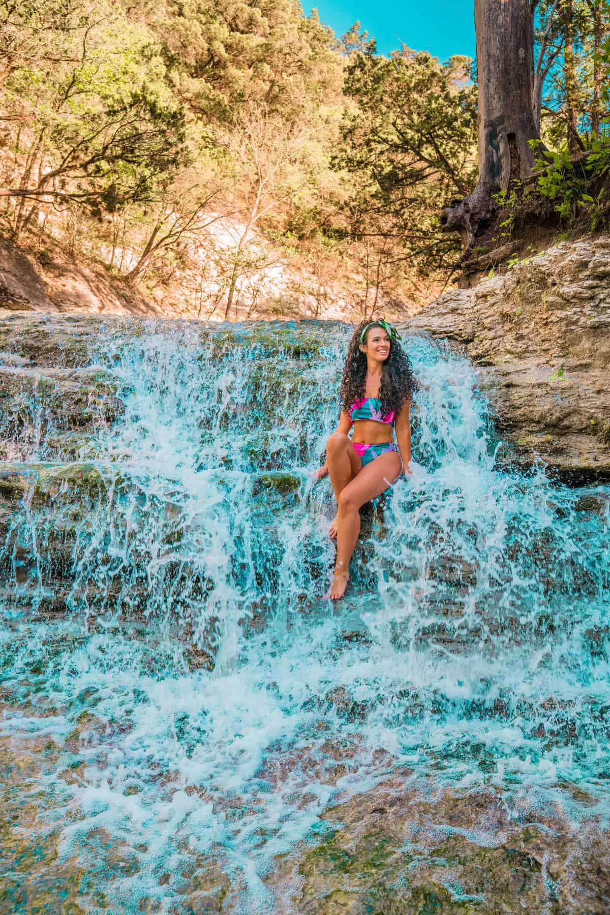 a woman sitting on a waterfall