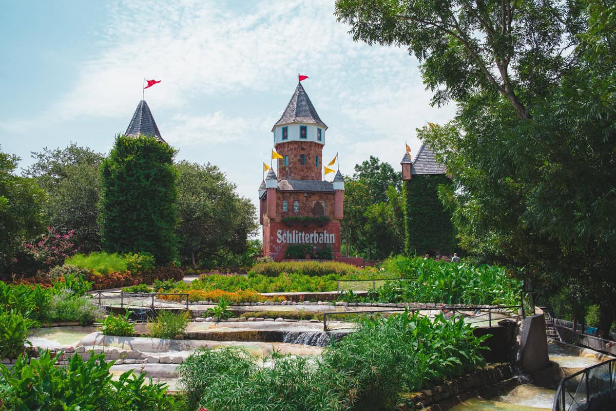 a castle with towers and a fountain in front of it