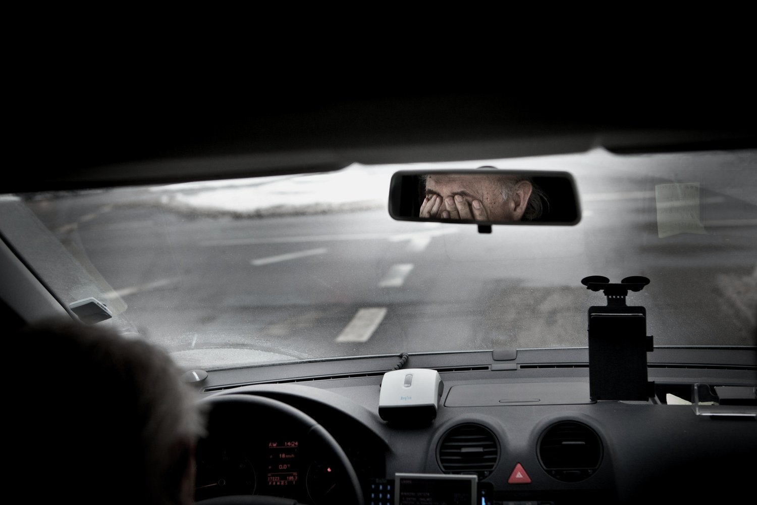 a man in a car looking at a man's face