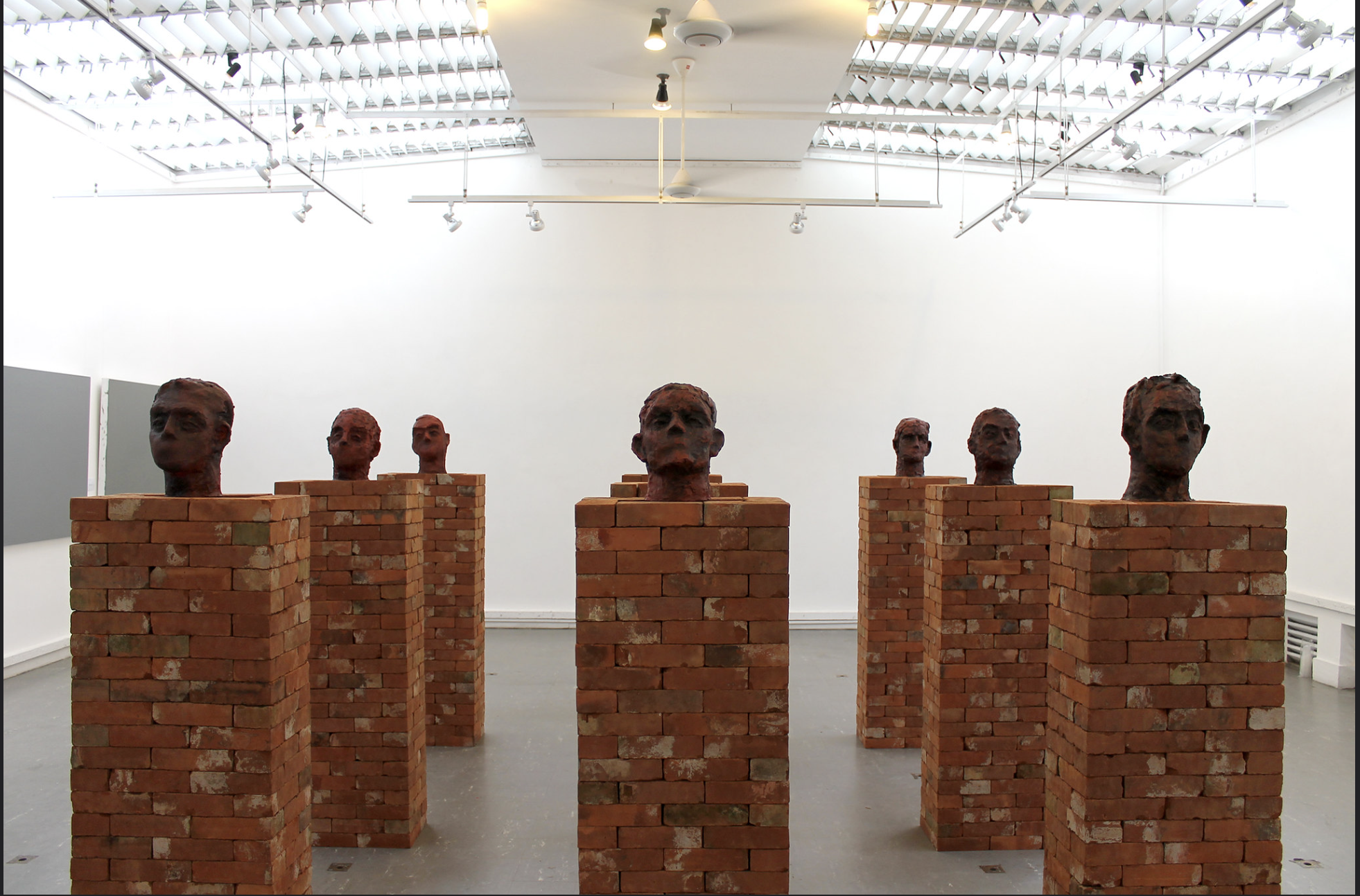 a group of brick pillars with heads on them