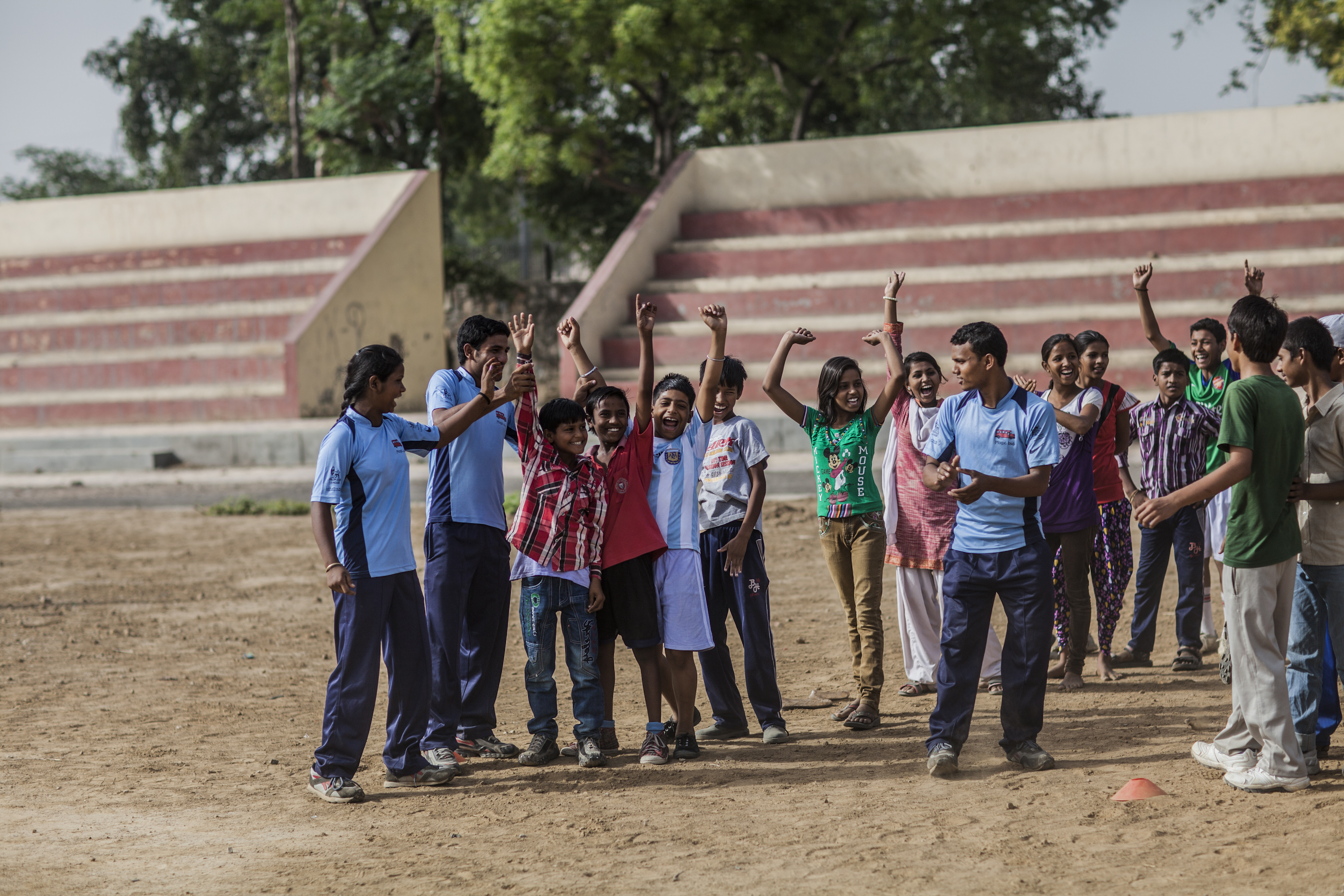 a group of people standing in a circle with their hands up