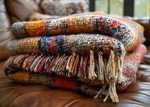 a stack of blankets on a couch