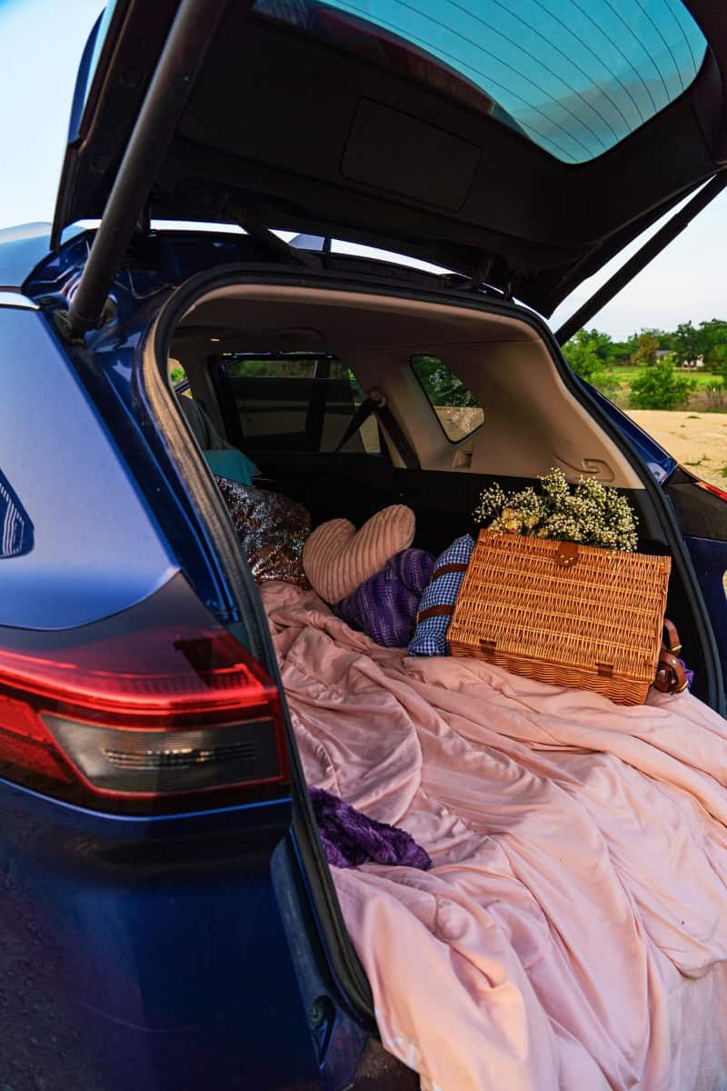 a car with a blanket and picnic basket