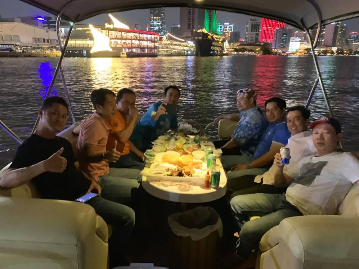 a group of people sitting around a table on a boat