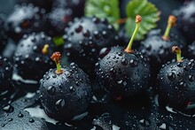 a group of black berries with water droplets on them