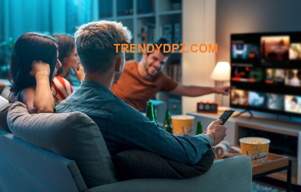 a group of people sitting on a couch watching television