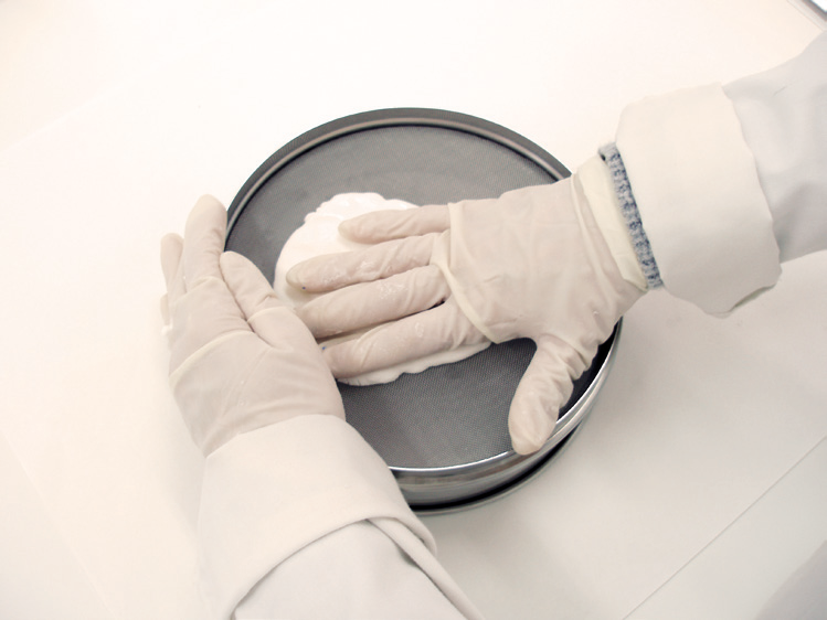 a person wearing gloves and gloves on a round metal container