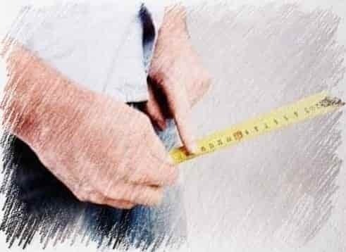 a close-up of a man measuring his waist